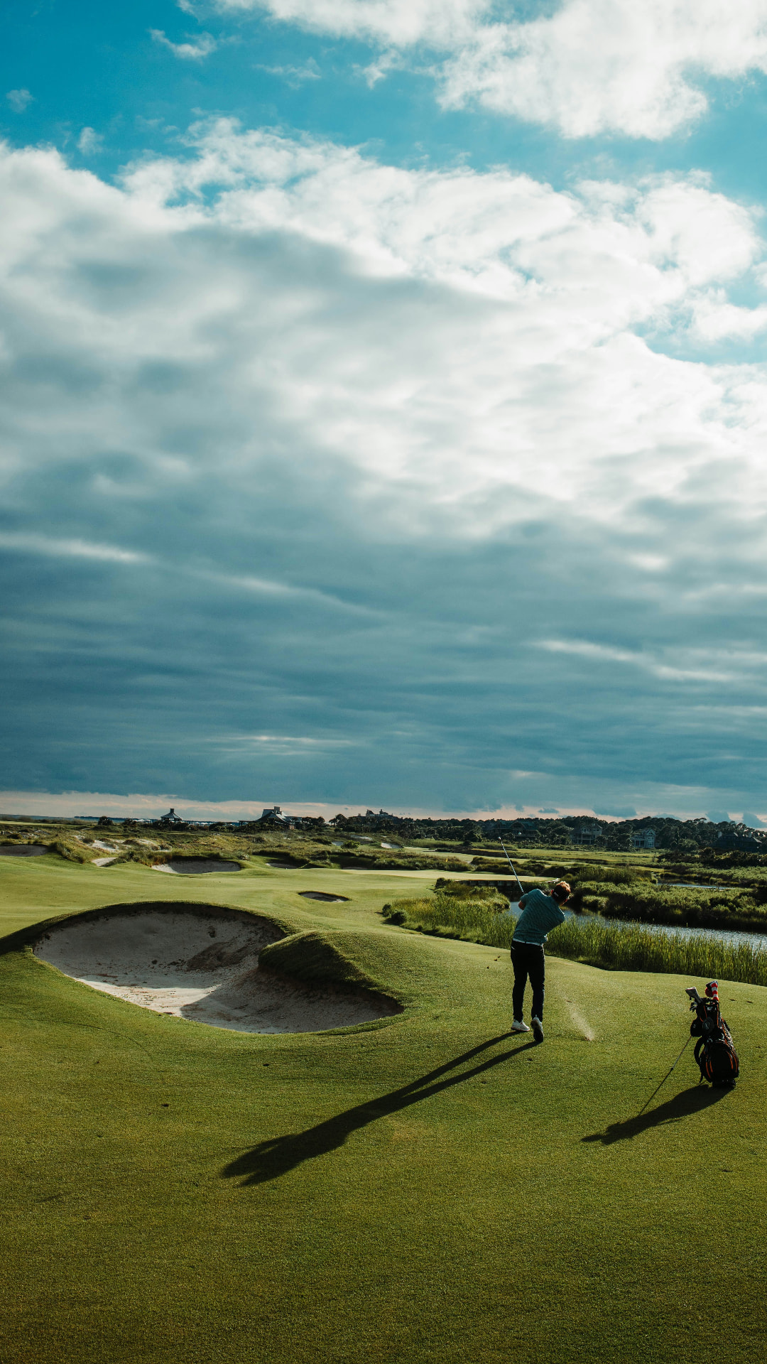 Golfer playing a links course beneath a dramatic sky