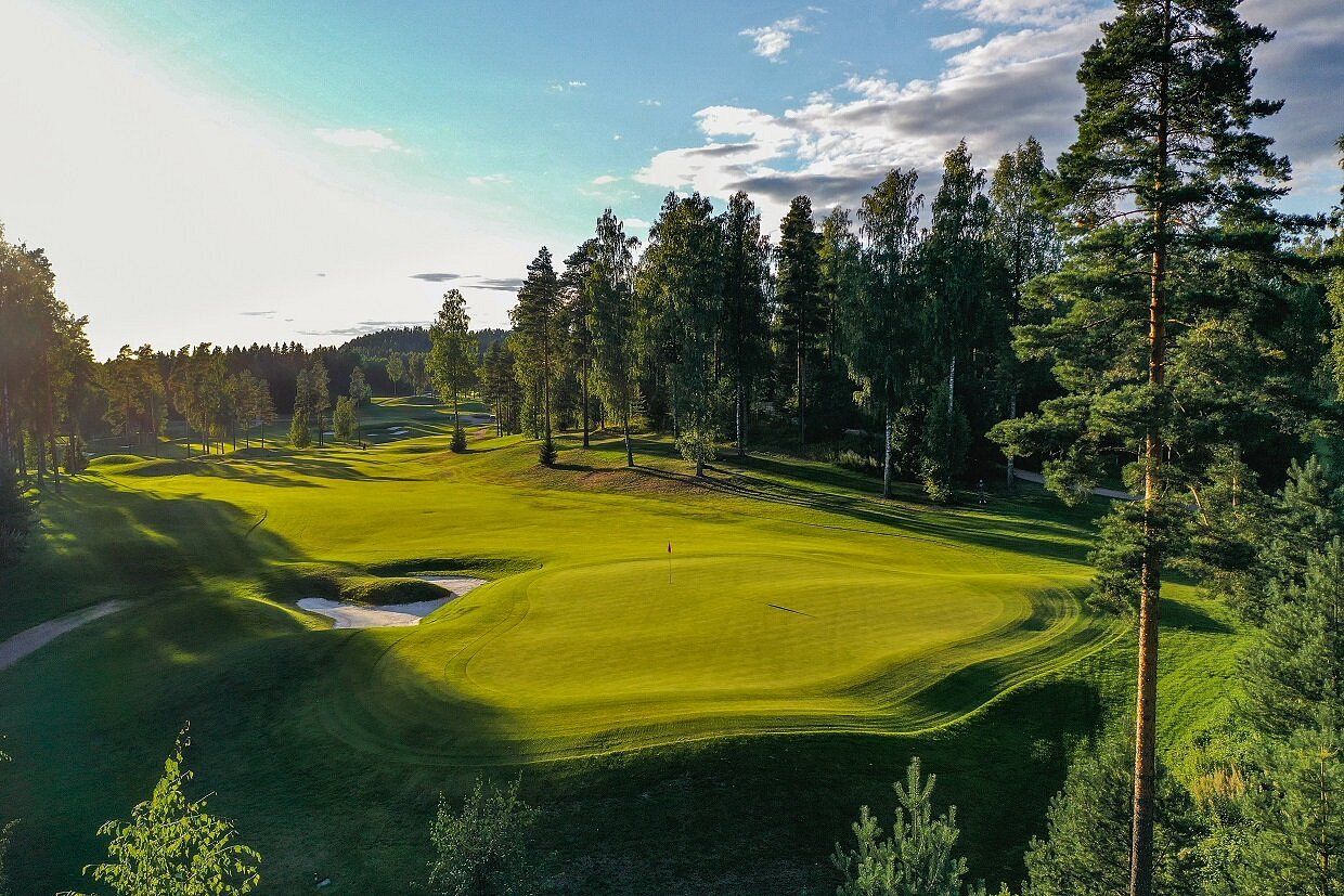 Green fairway winding through pine trees on a Finnish golf course