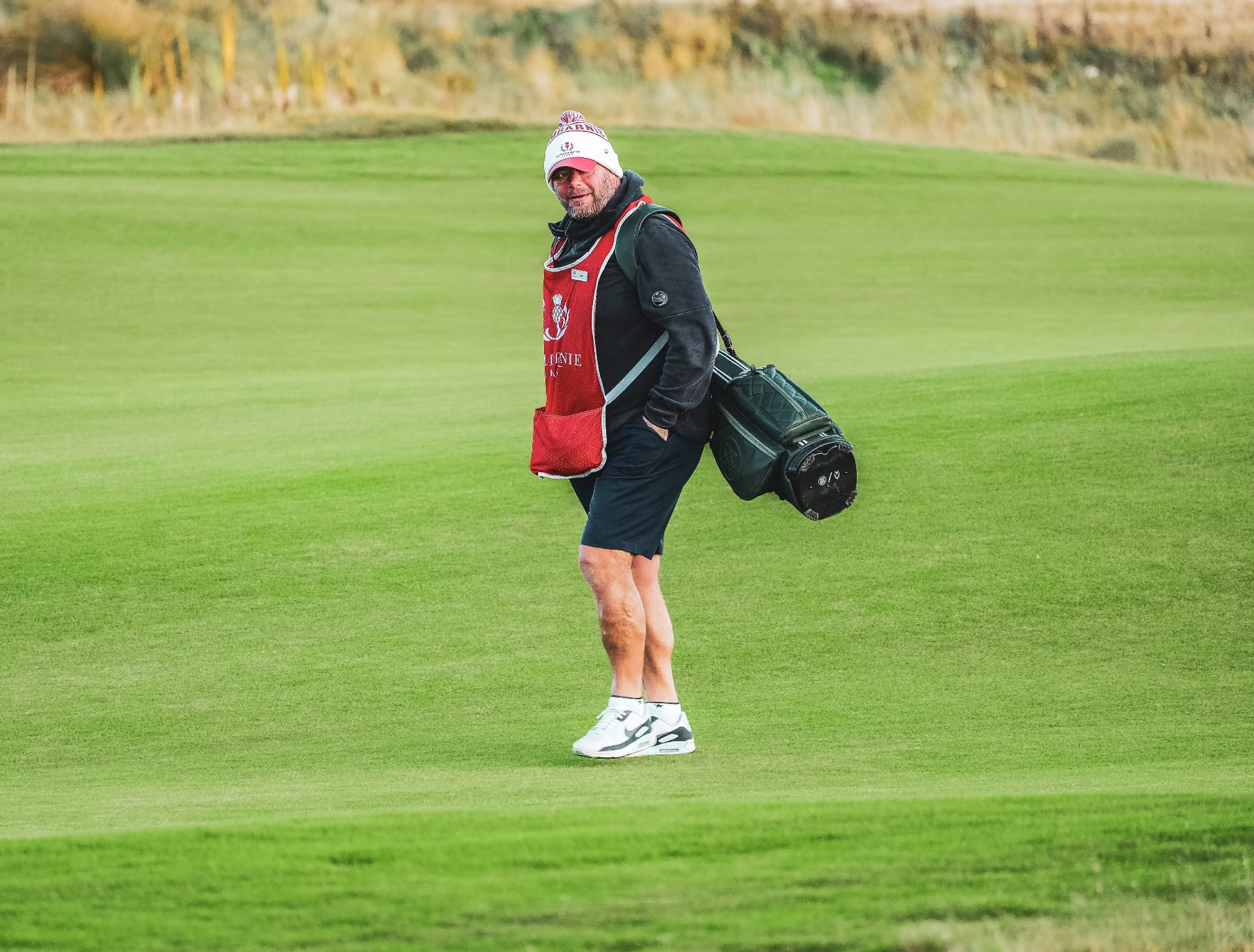 Golfer carrying a bag on a Scottish golf course